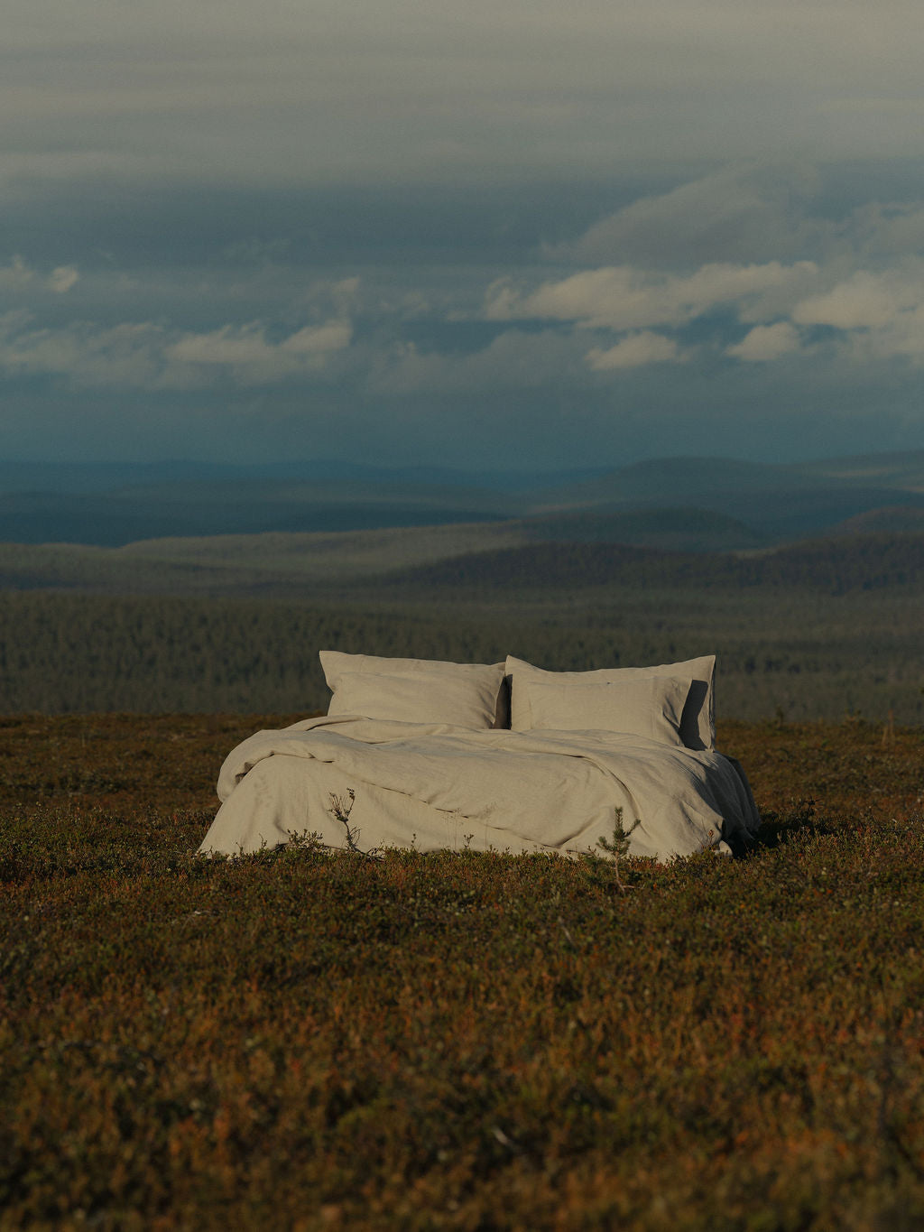Beiget lakanat tunturimaisemassa. Pussilakana ja tyynyliinat hamppua.